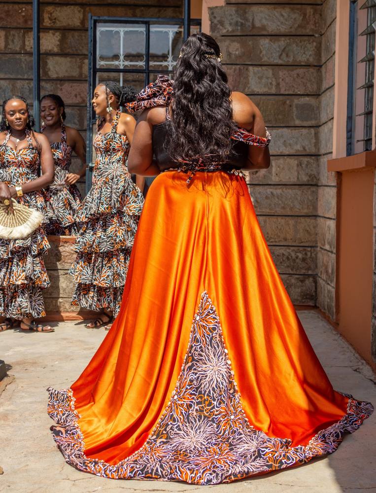 The train of a custom orange satin and Ankara gown